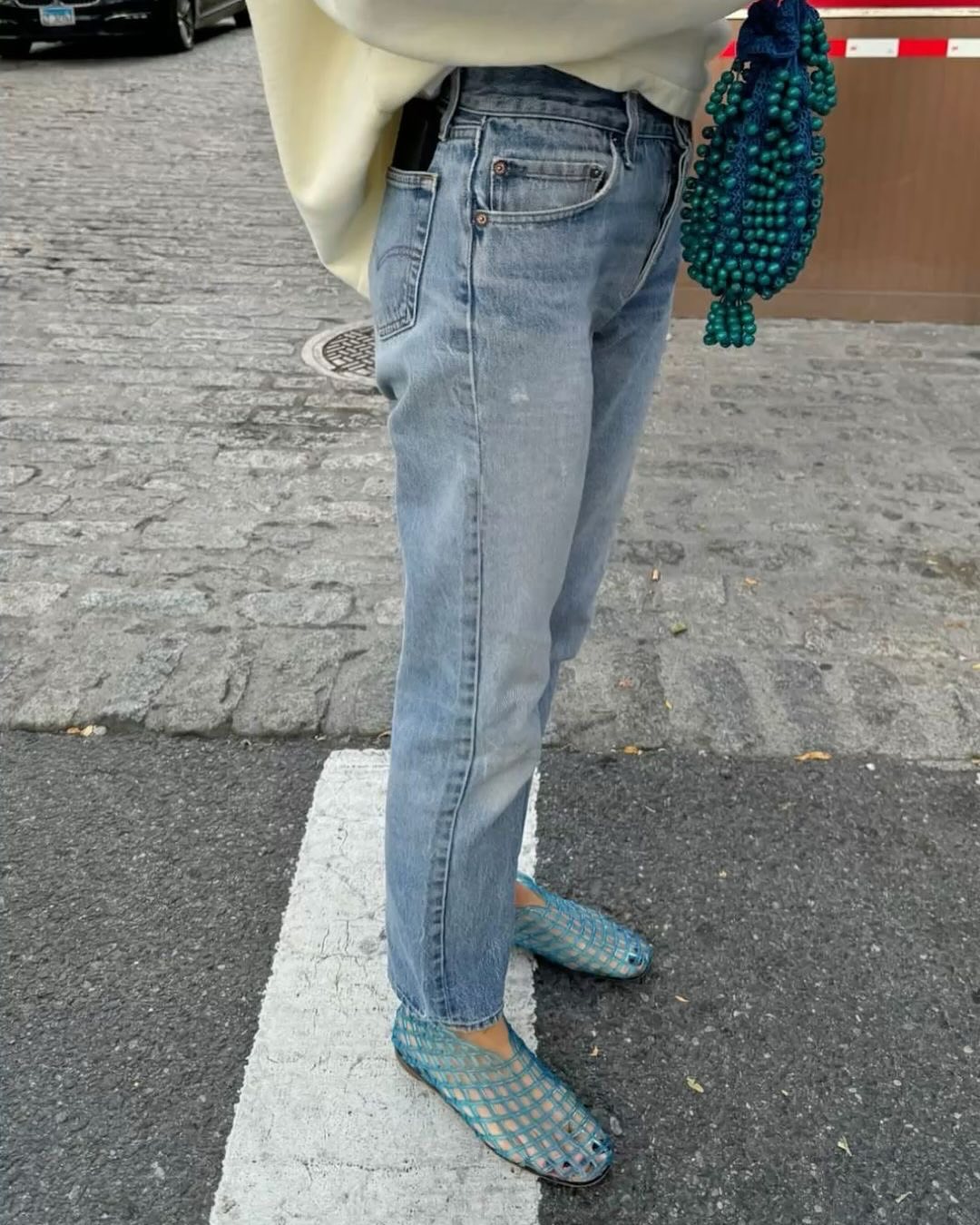Ženska, ki ima oblečene jelly shoes in kavbojke