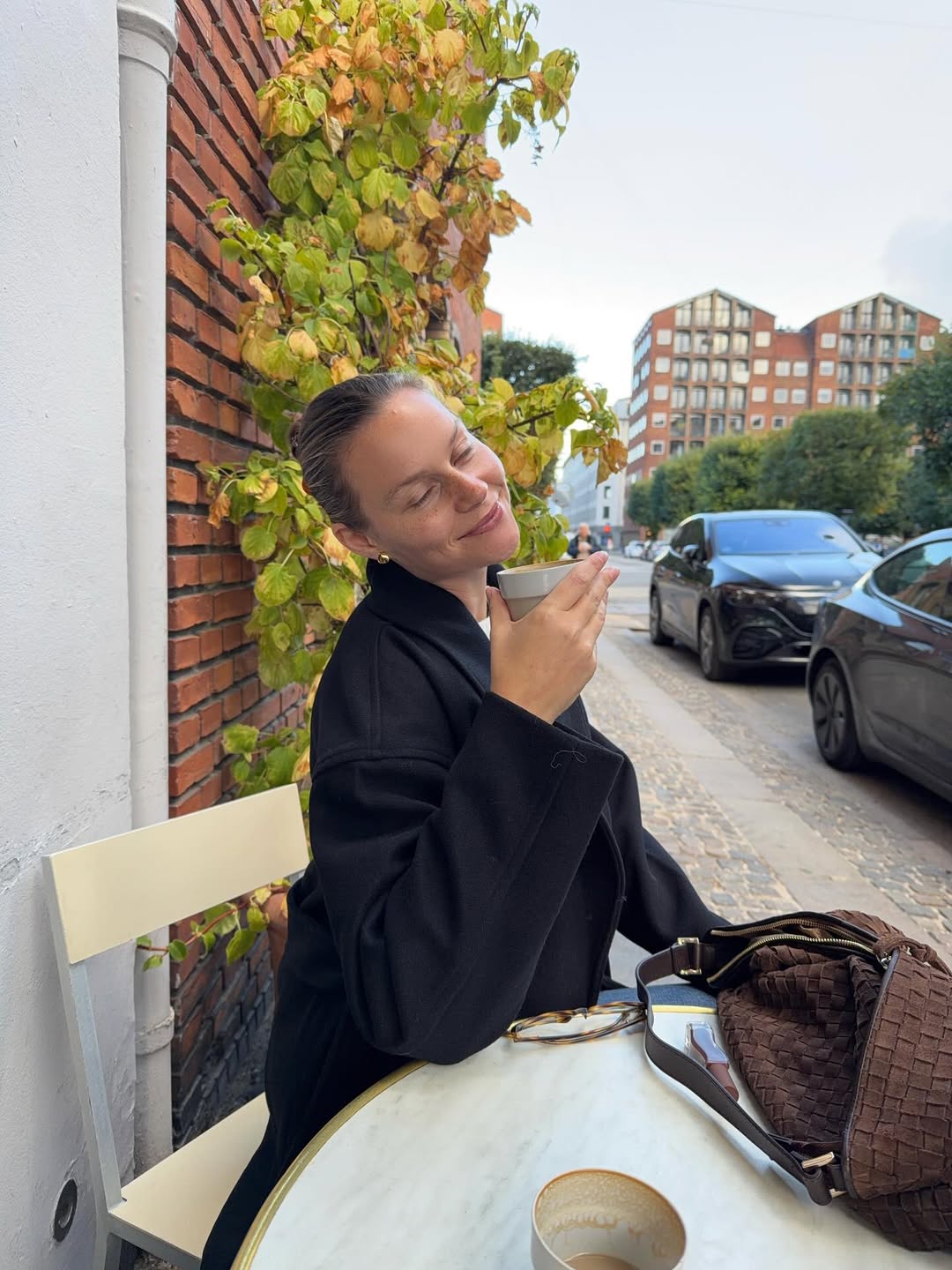 ženska z sijočo kožo pozira pred kamero