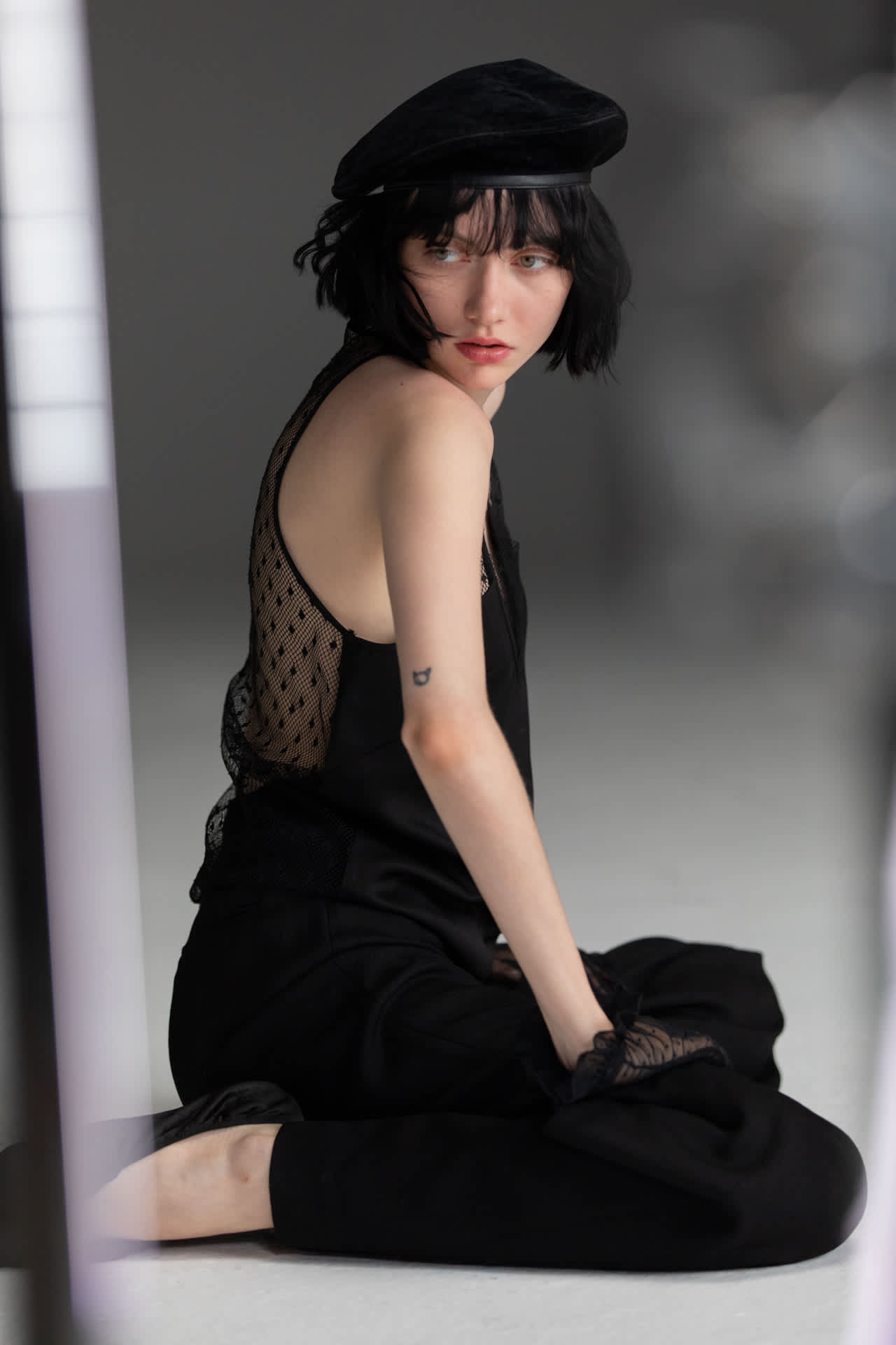 ženska v črni baretki v zaodrju