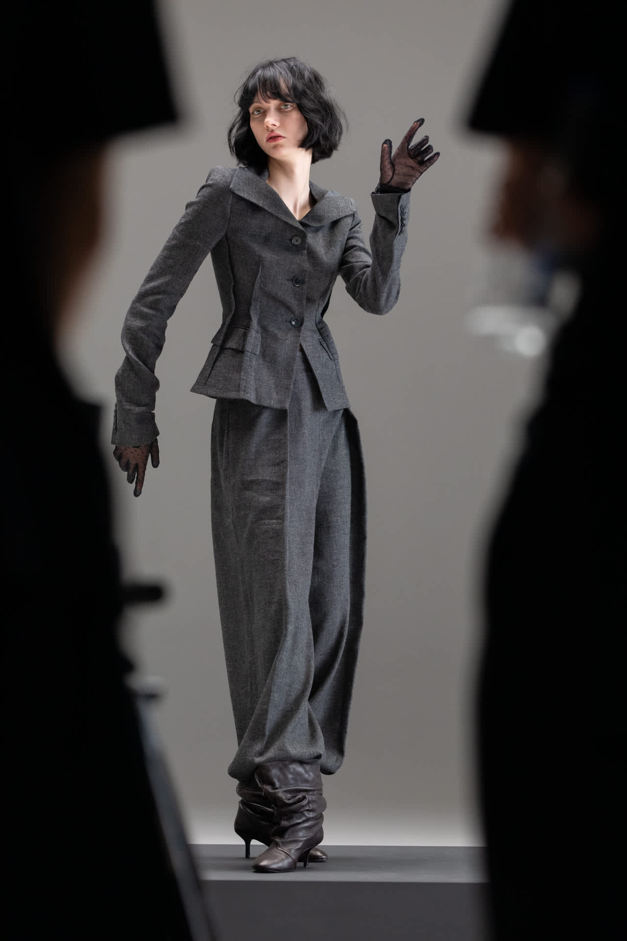 ženska v sivi obleki v zaodrju