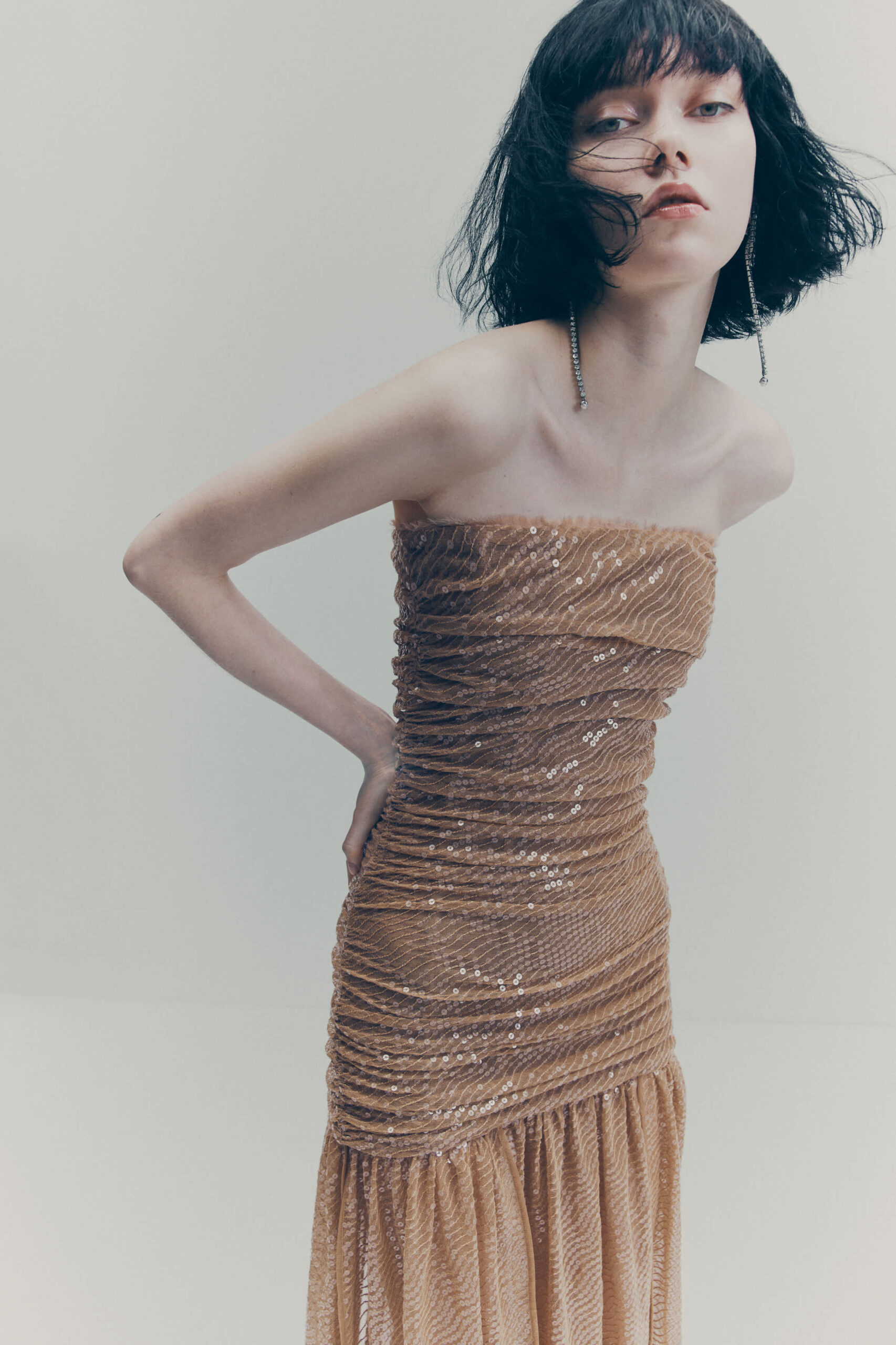 ženska v zlati bleščeči obleki