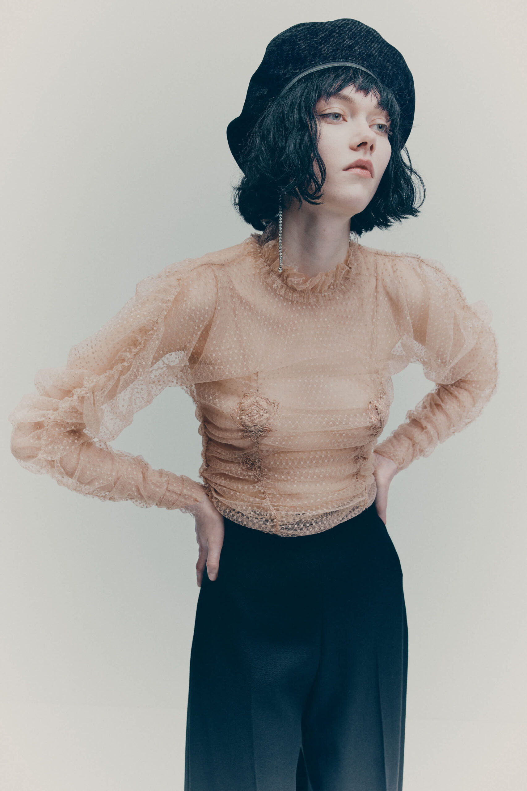 ženska s prosojno bluzo in čepico