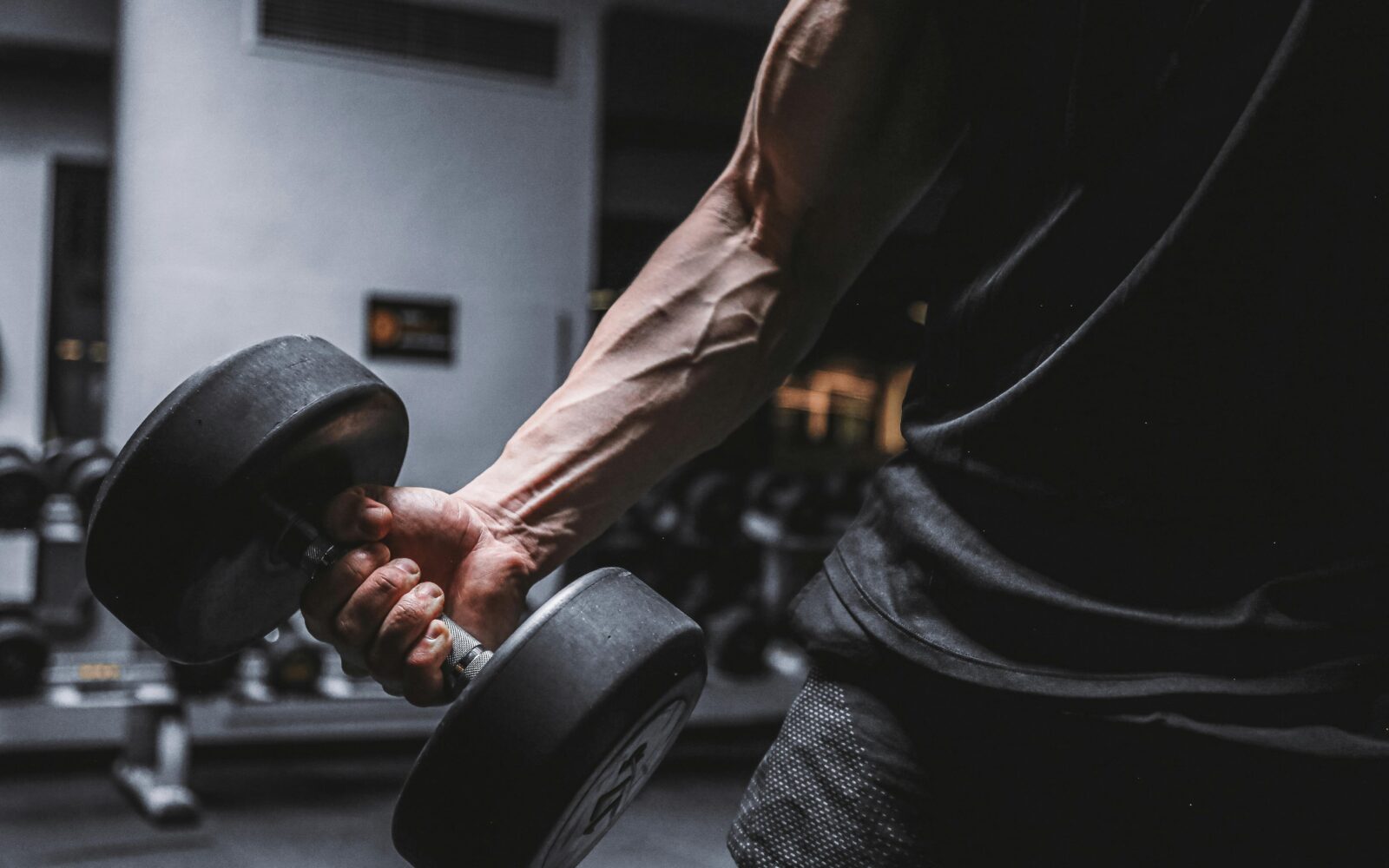 moški z mišičasto roko in utežmi