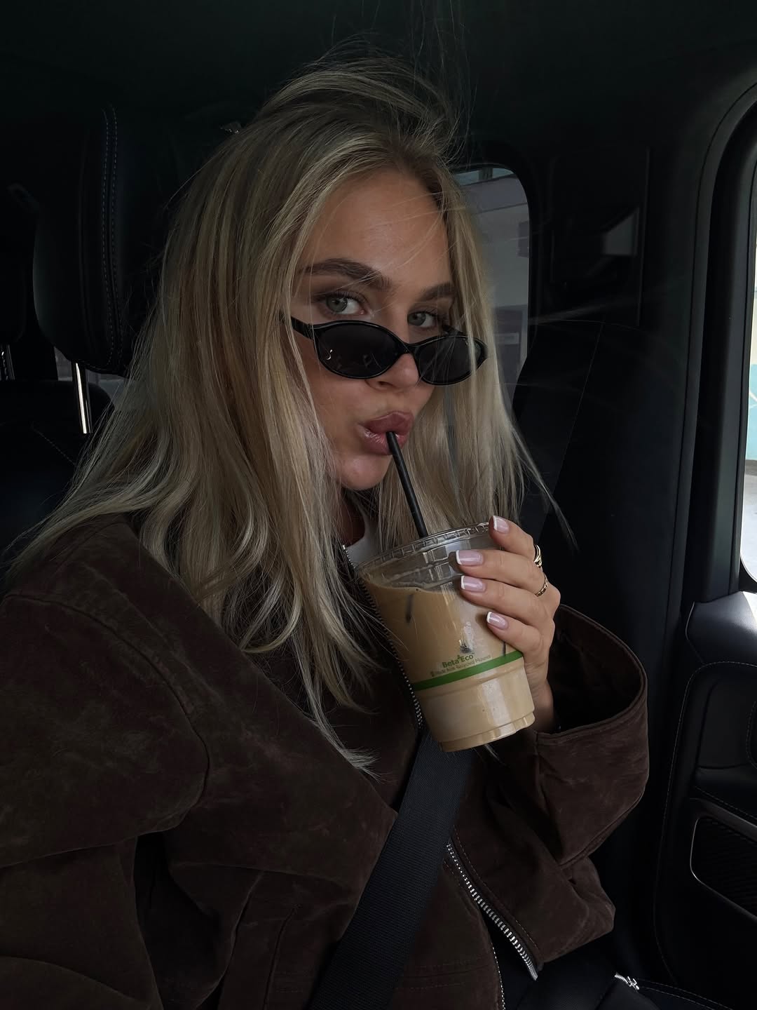 Ženska s sončnimi očali, ki pije kavo