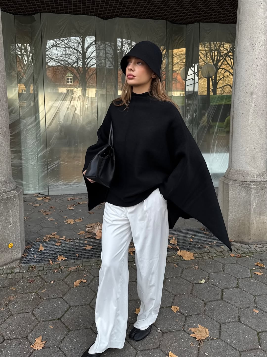 Ženska, ki nosi klobuk "cloche" in pozira na ulici