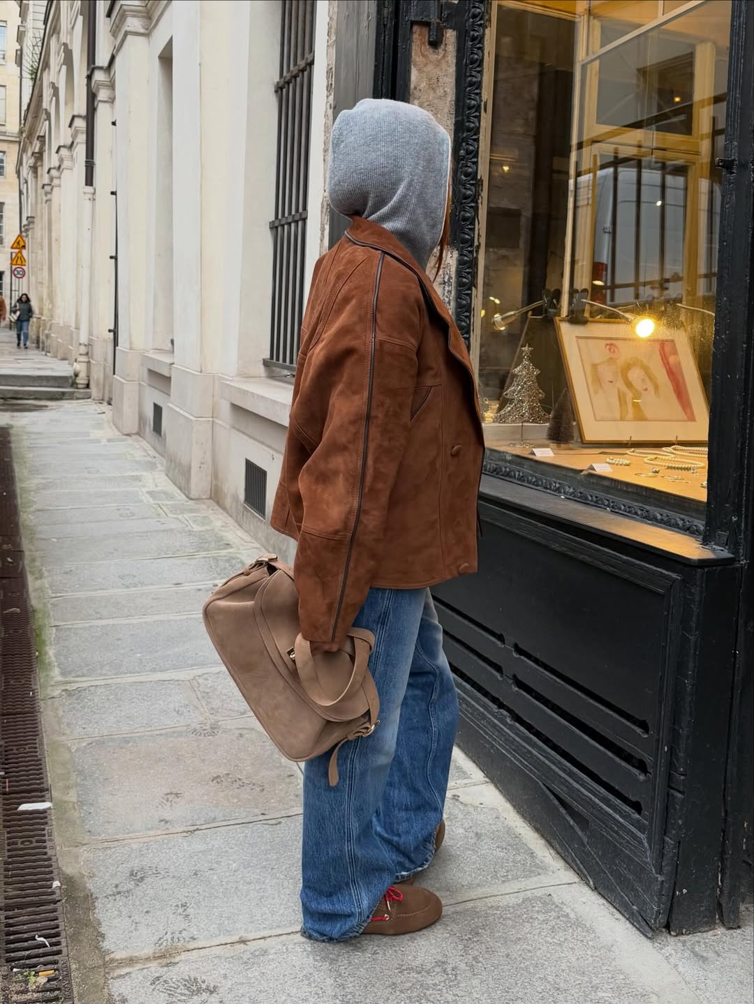 Ženska v kavbojkah, ki gleda v izložbo na ulici