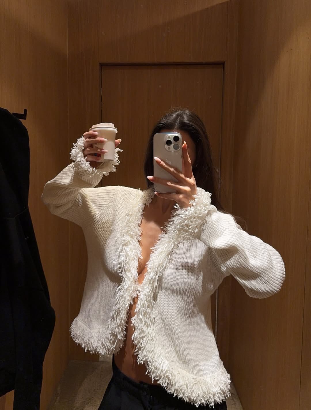 Ženska, ki se slika v garderobi, s kavo v rokah