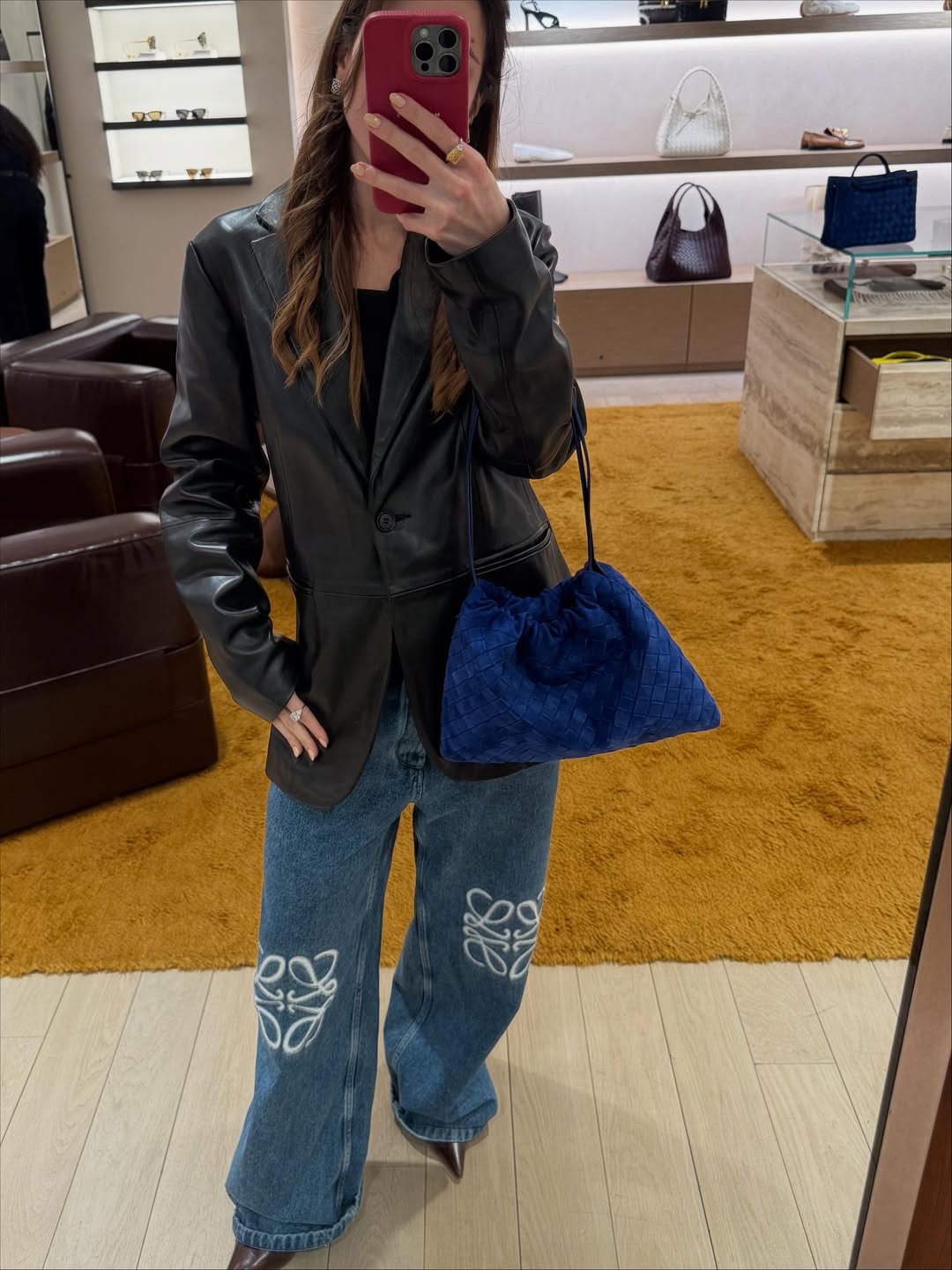 Ženska s kobaltno modro torbico, ki se slika v ogledalu