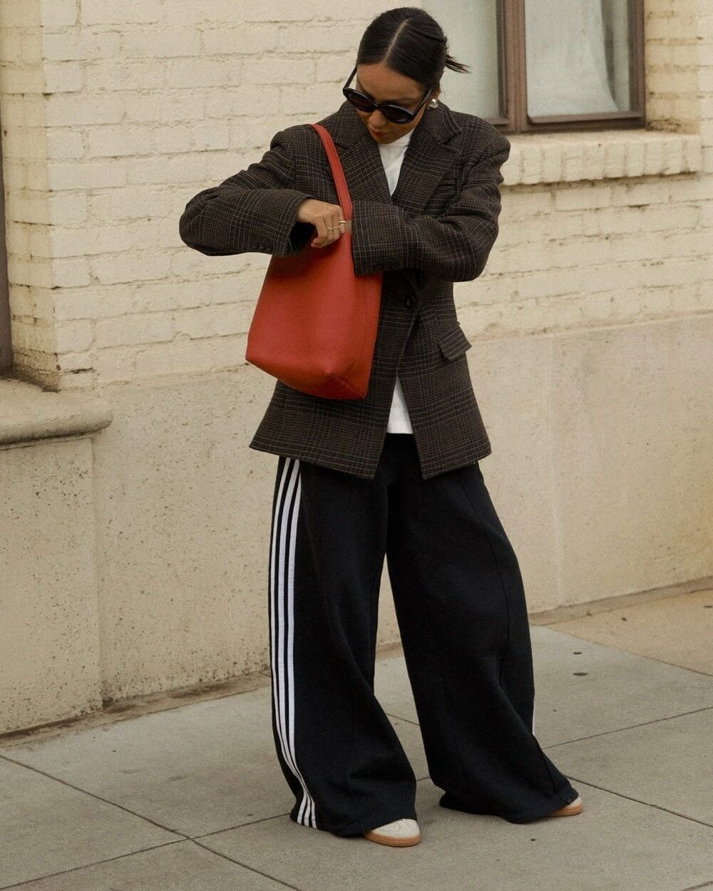 Ženska v suknjiču in trenirki na ulici