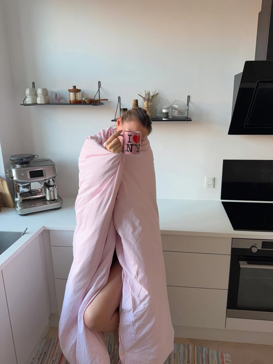 Ženska, ki je zavita v odejo in s skodelico v roki