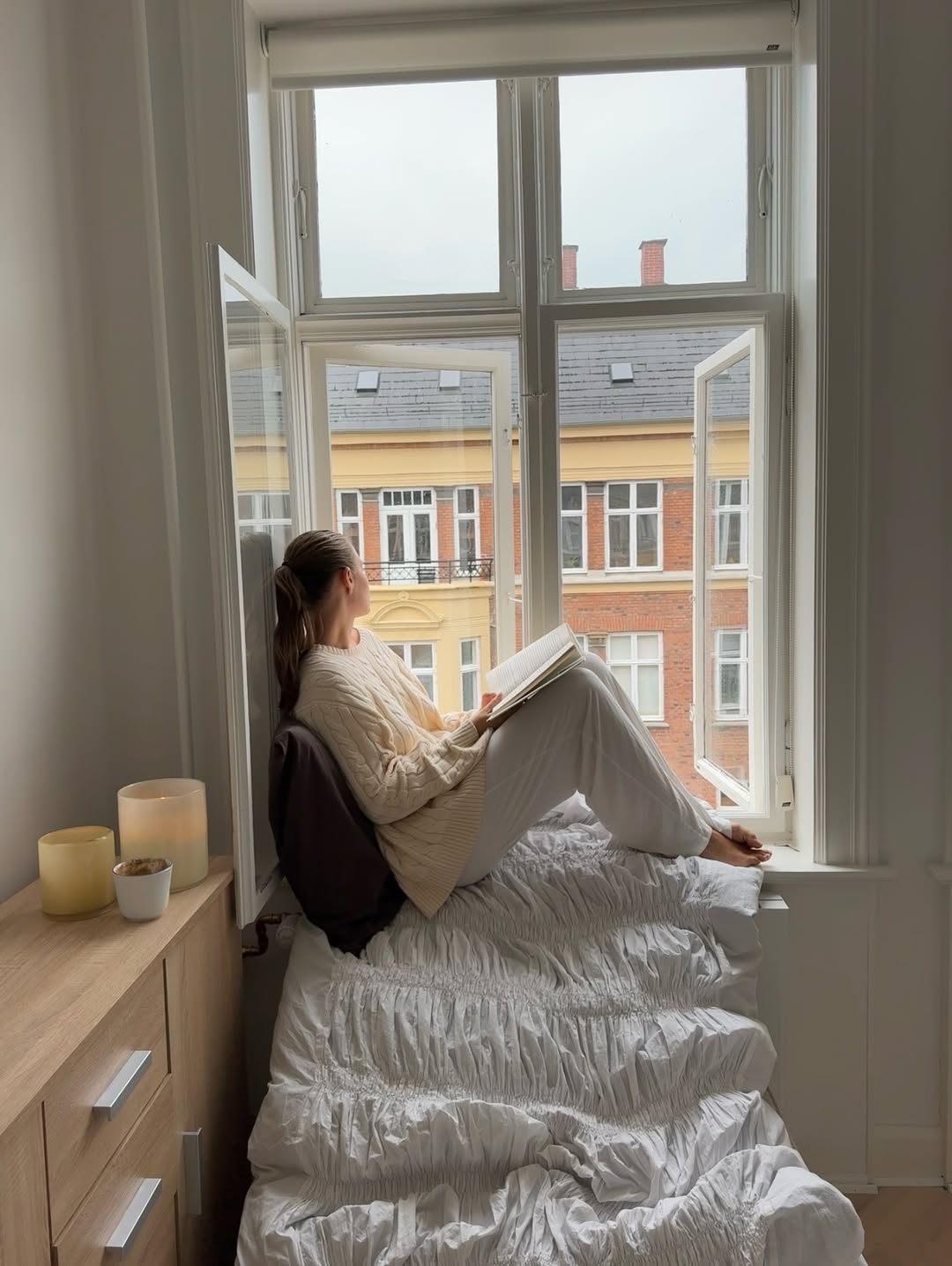 Ženska, ki sedi na oknu